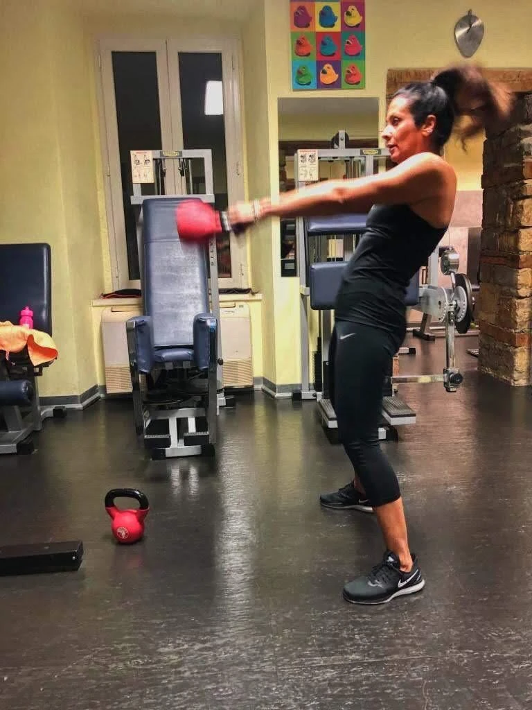 Una cliente si allena con i guantoni da pugilato in palestra