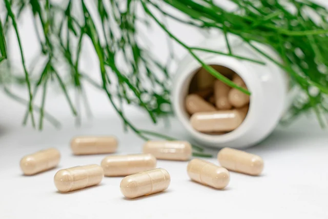 Capsule accanto a un flacone bianco senza etichetta, su un fondo chiaro