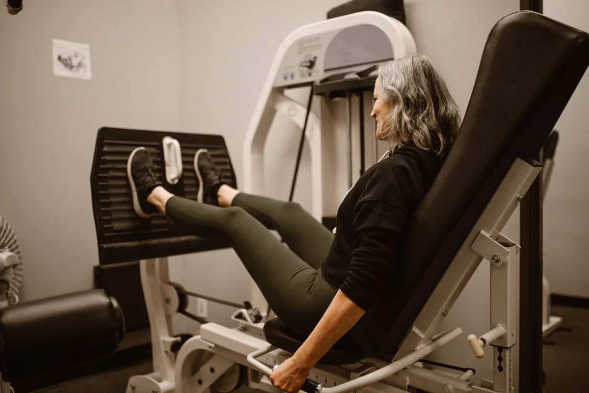 Una donna si allena alla leg press in palestra